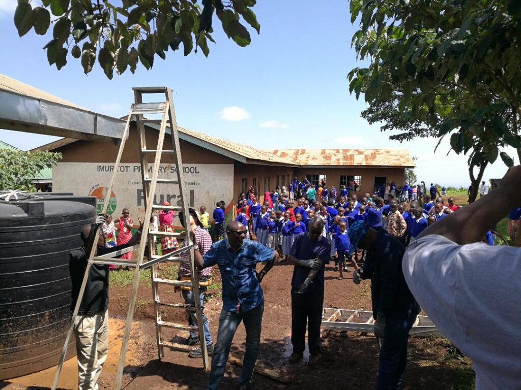 Children at Imurtot gather as the EWB and WILK partnership installs the rainwater harvesting systems.