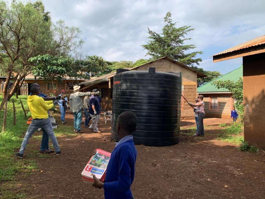 The team adjusts one of the 10,000 liter tanks used in the rainwater catchment process